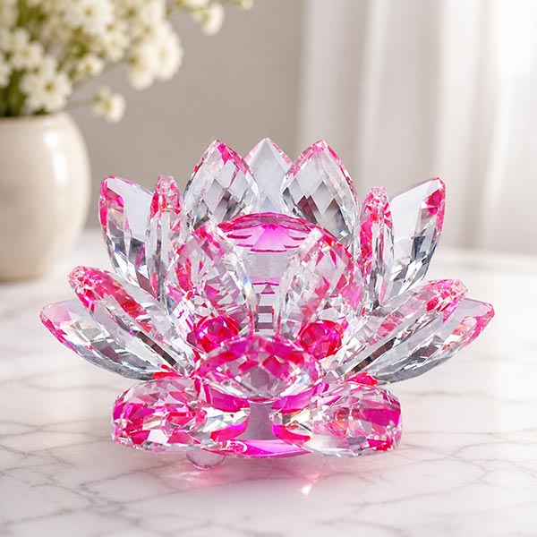 Pink crystal lotus candle holder on a white marble surface, sparkling and translucent.